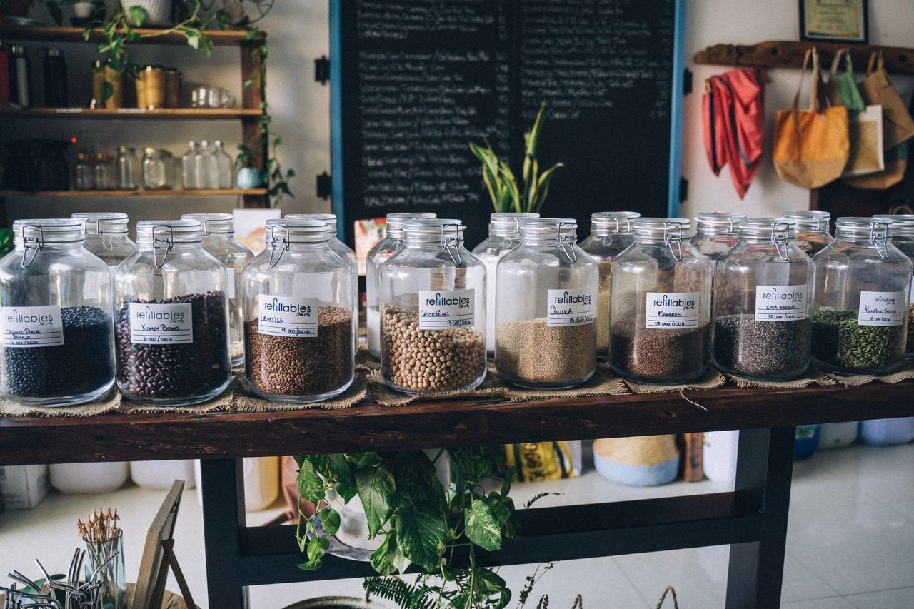 A zero waste store featuring refillable jars filled with seeds and grains promoting sustainable shopping.