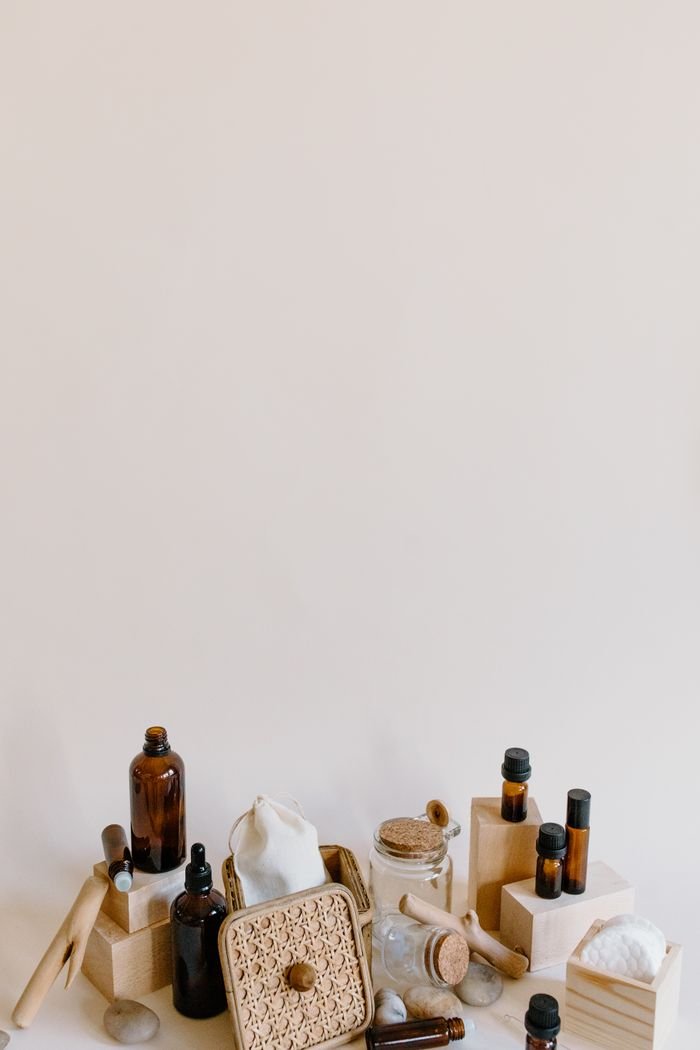 Elegant arrangement of essential oil bottles and accessories on a minimalist beige background.
